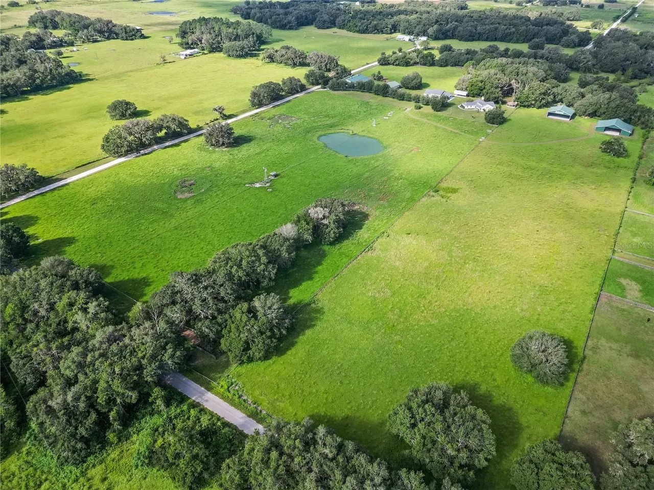 Closer aerial view of the Center Hill homesite, pond, and neighboring structures