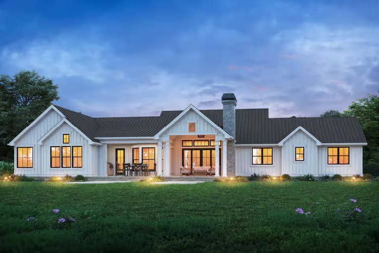 The Cedar Run — rear exterior at dusk with covered patio and warm lighting