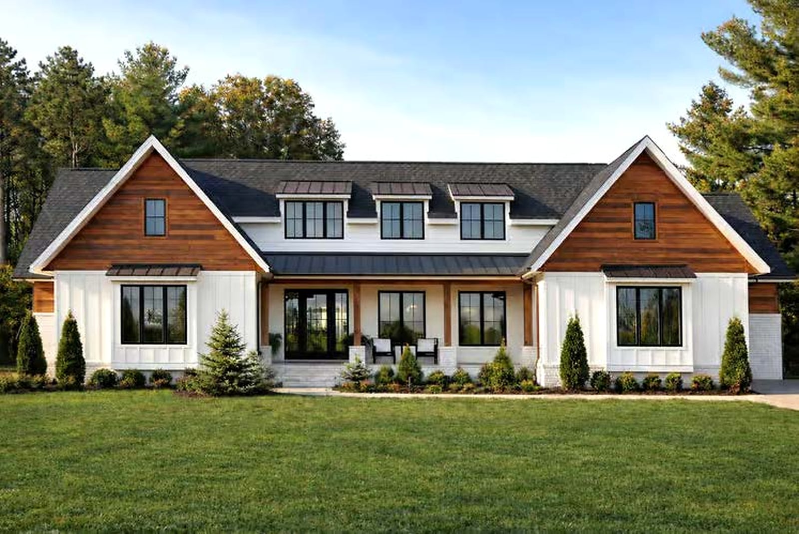 The Winchester — modern farmhouse exterior with wood-tone gables, black windows and a covered front porch