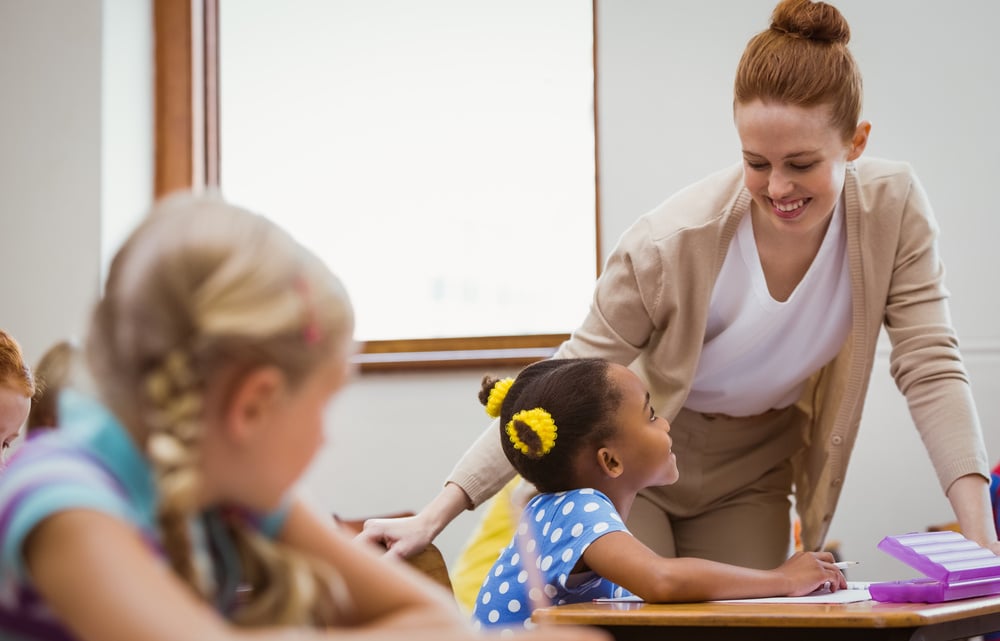 Teacher helping a student in an elementary classroom